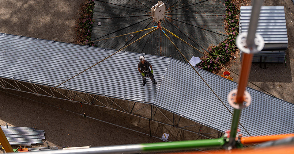 Gerüstbauer macht große Überdachung für den Kran bereit