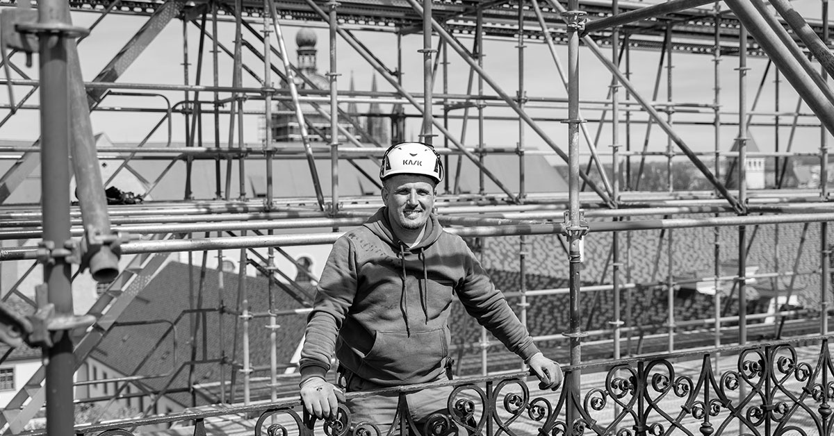 Gerüstbauer auf einem Gerüst hoch über Regensburg