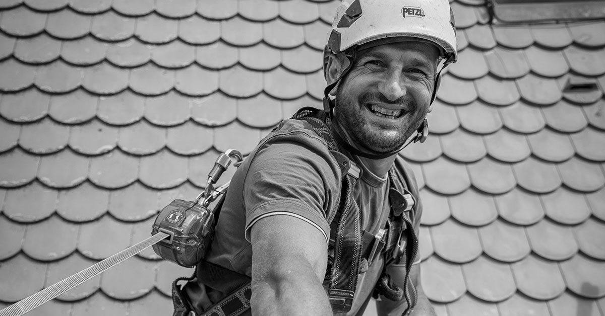 Ein Gerüstbauer auf einem Kirchendach